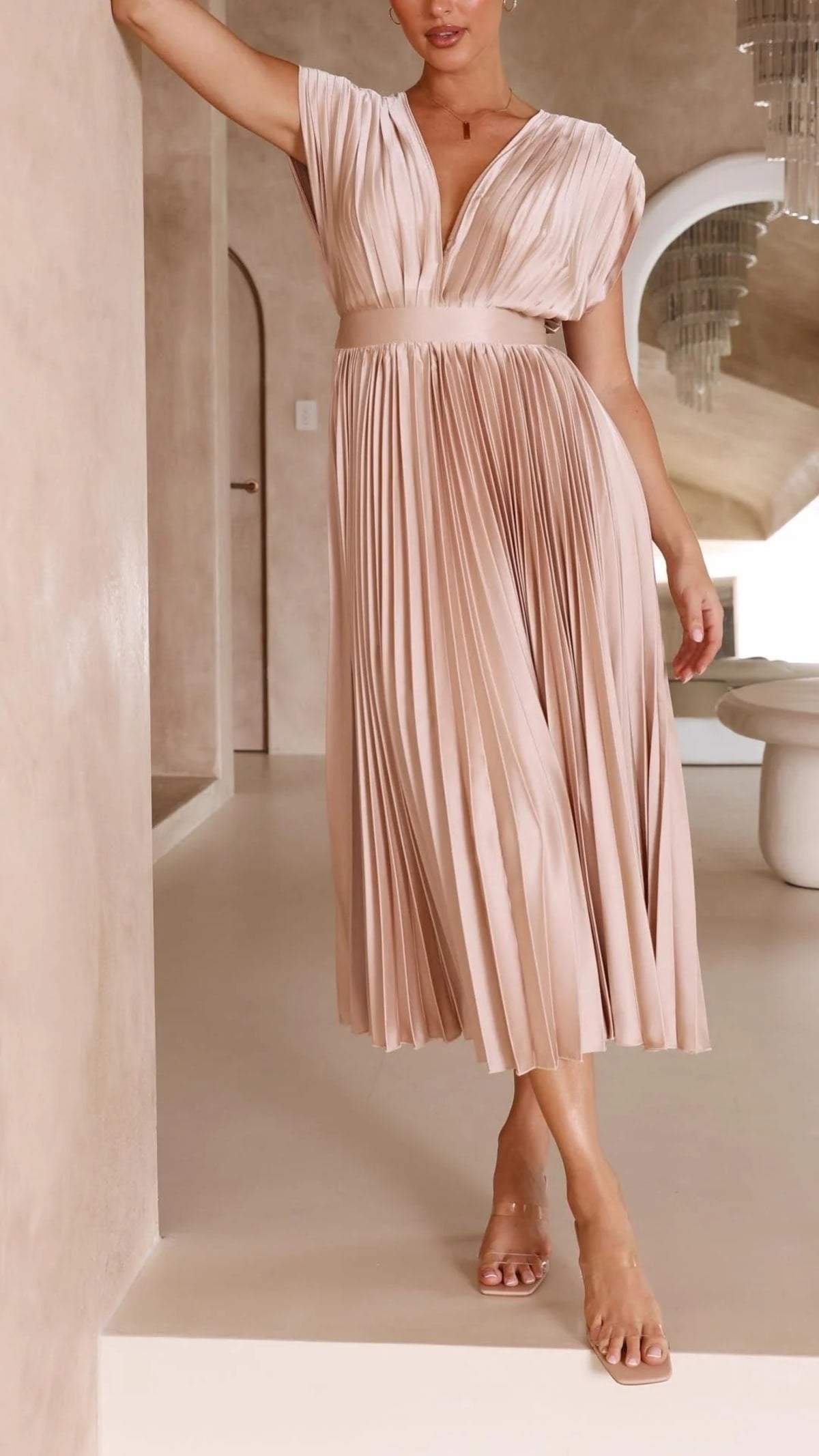 Woman wearing a pleated maxi dress with a V-neckline.