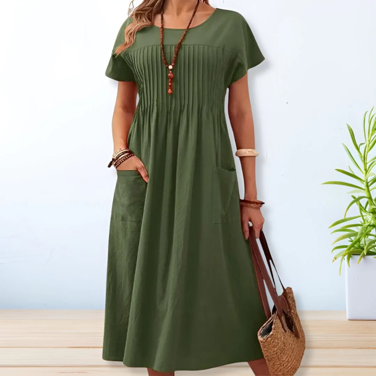 Woman wearing a mid-length relaxed day dress with short sleeves and pockets.