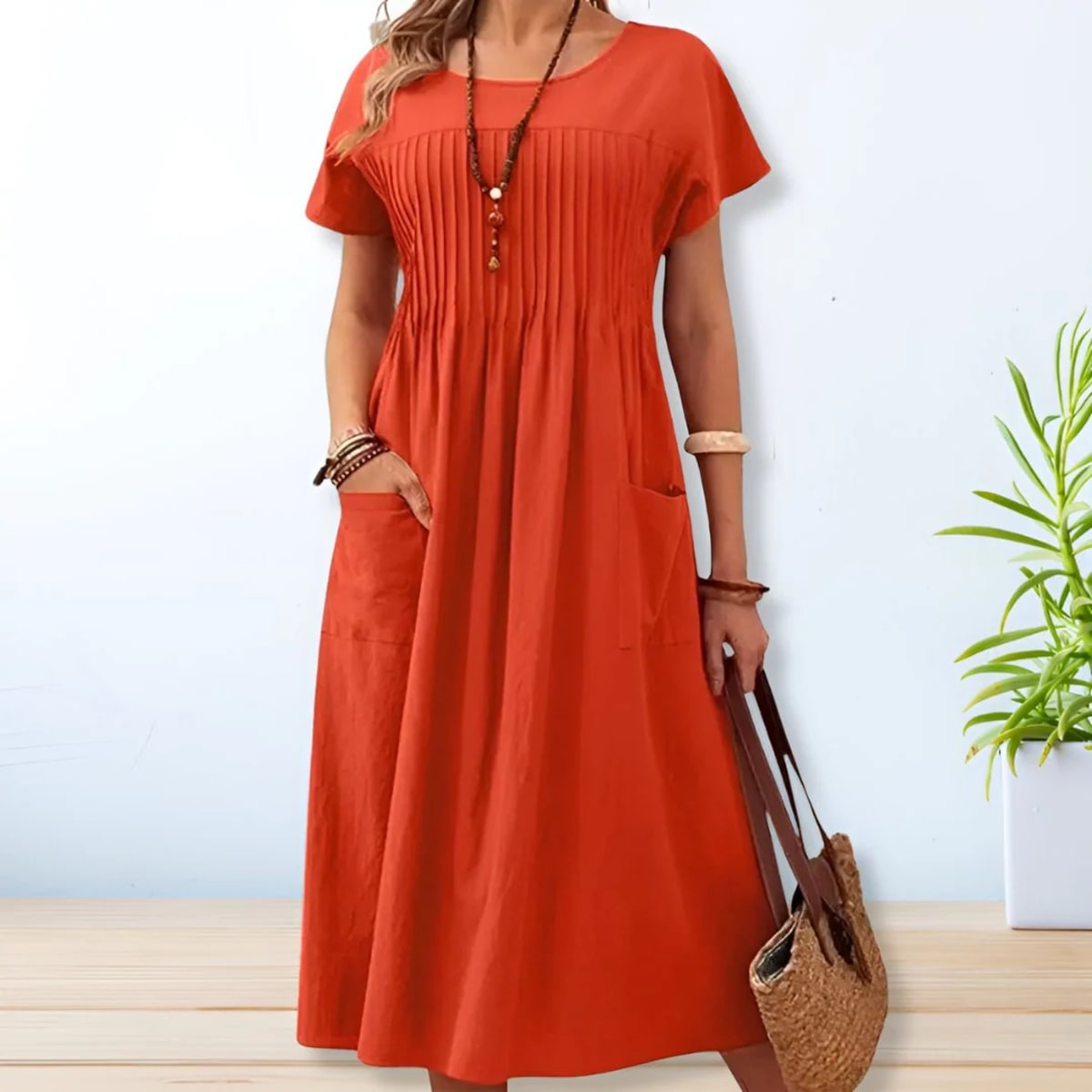 Woman wearing a mid-length relaxed day dress with short sleeves and pockets.