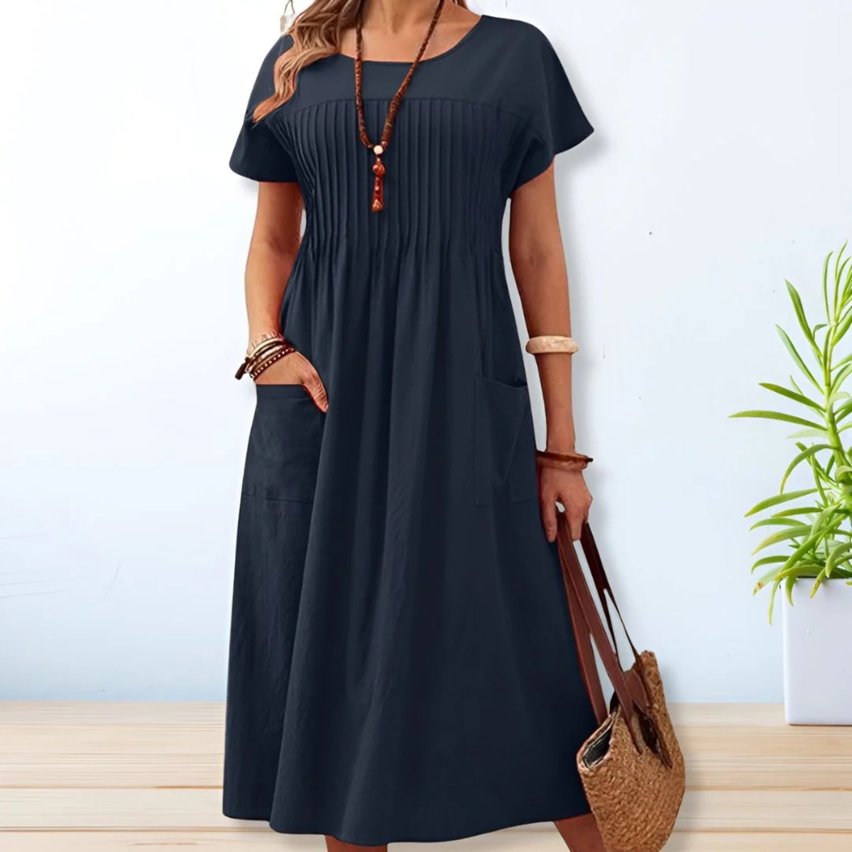 Woman wearing a mid-length relaxed day dress with short sleeves and pockets.