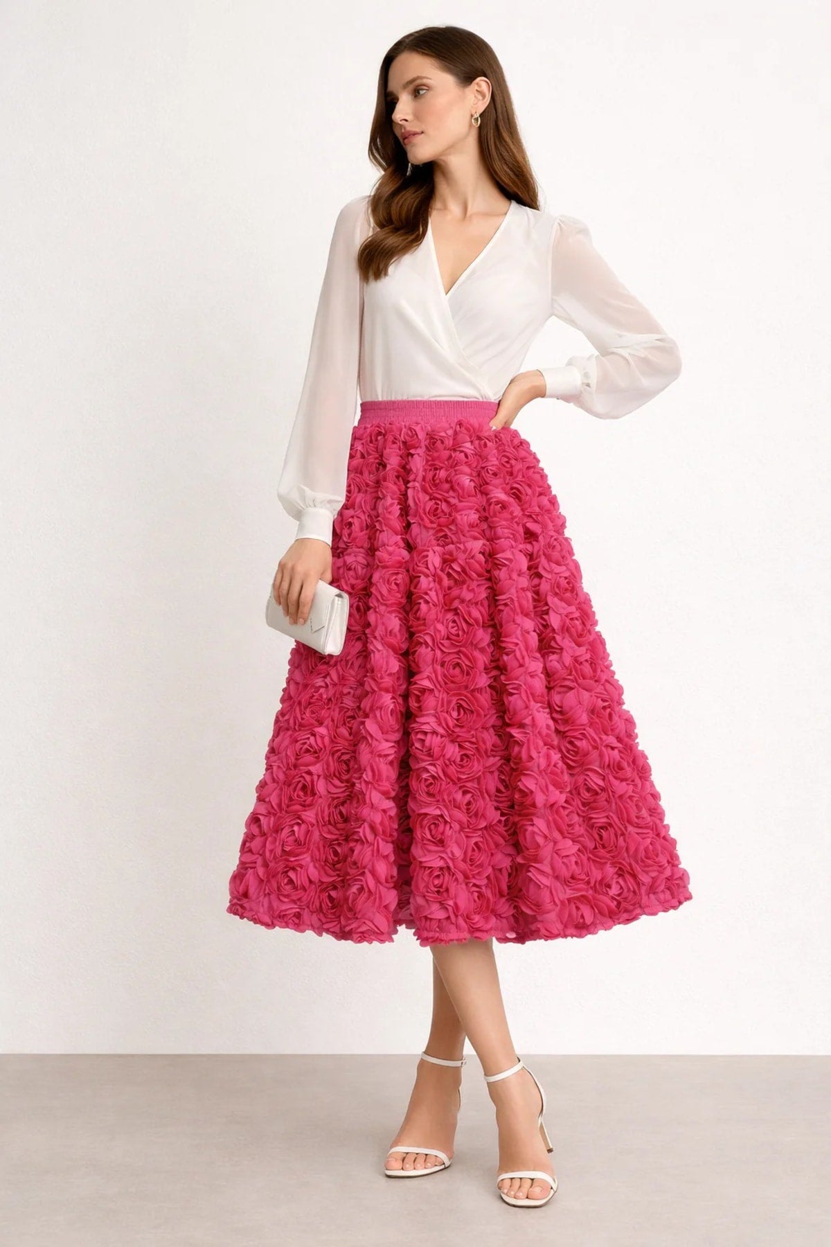 Woman wearing a midi skirt with rose appliques and a white blouse.