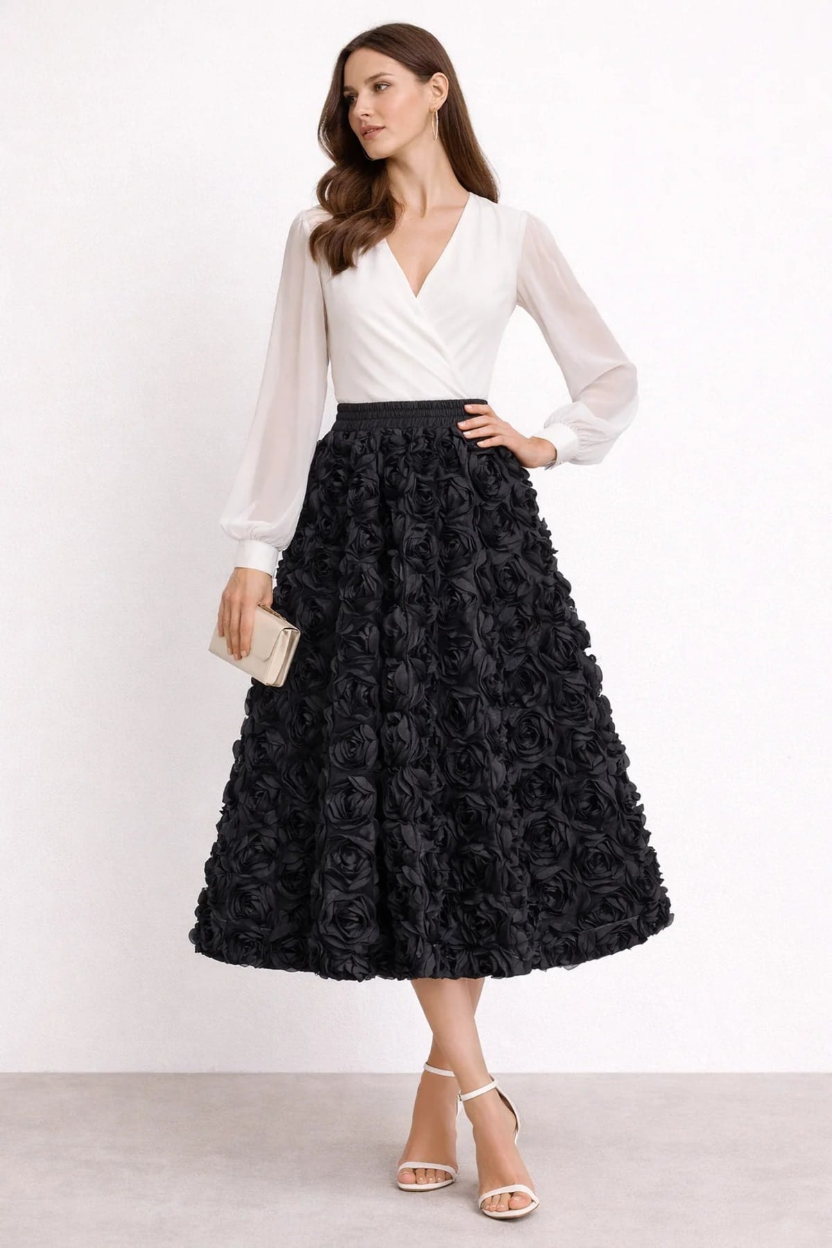 Woman wearing a midi skirt with rose appliques and a white blouse.