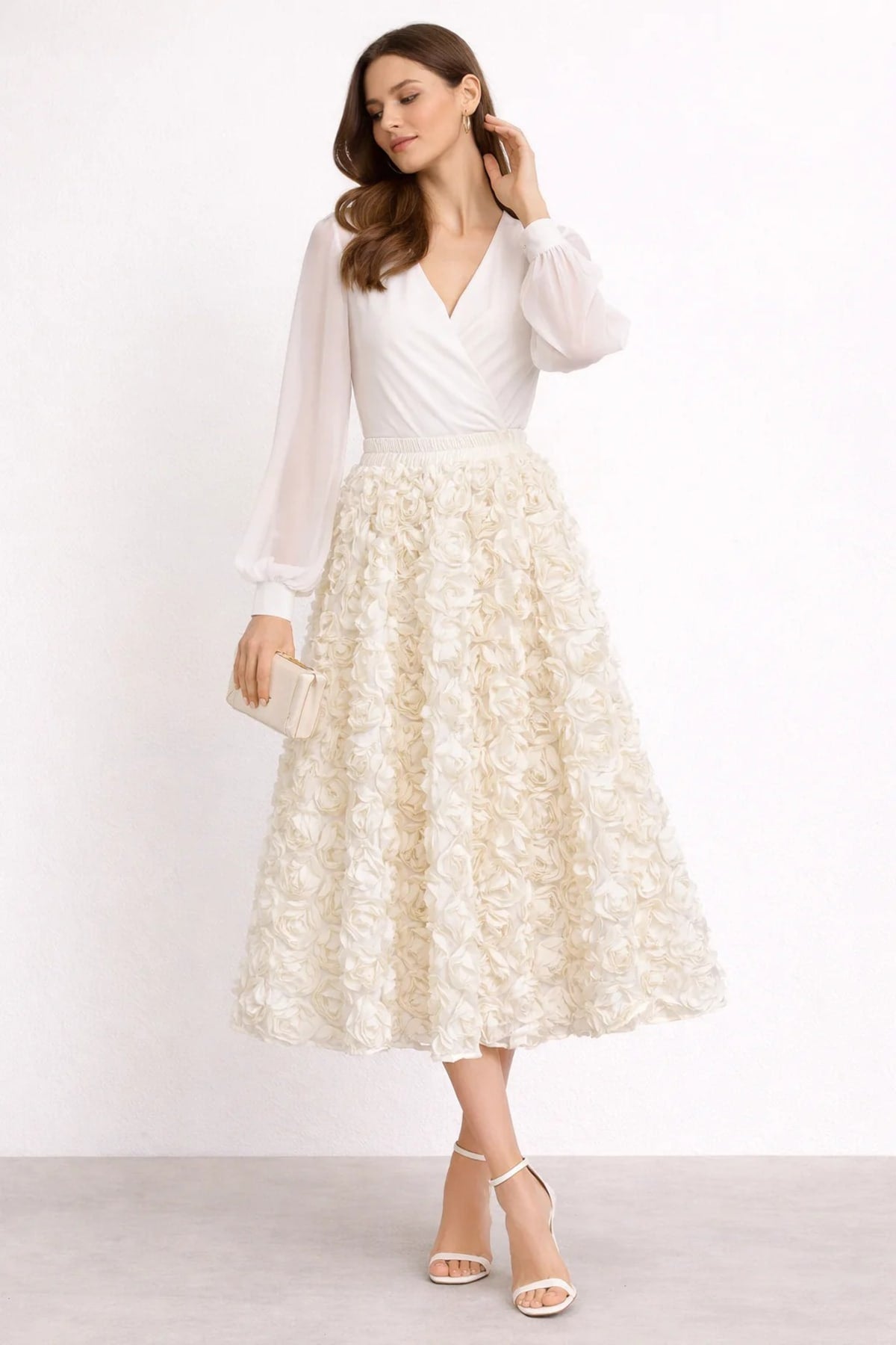 Woman wearing a midi skirt with rose appliques and a white blouse.