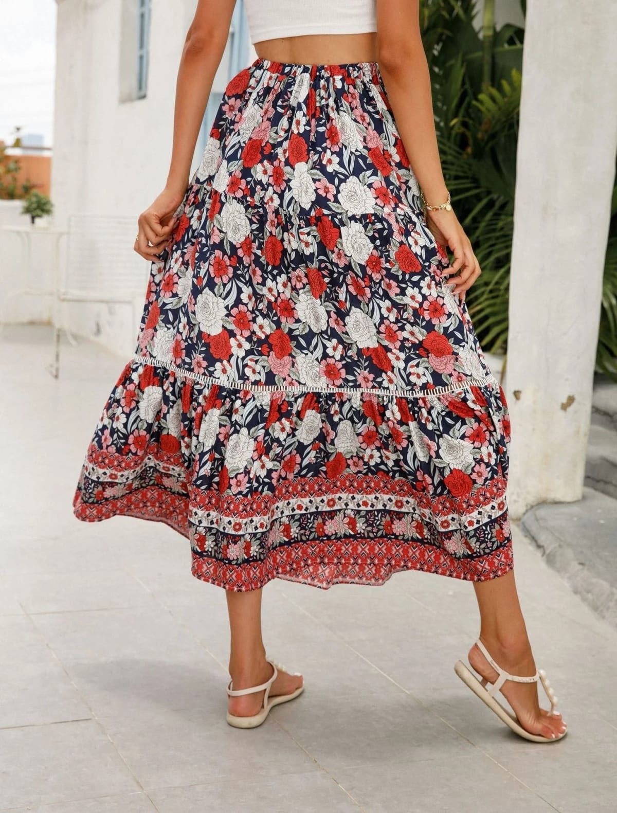 Woman wearing floral tiered midi skirt with crop top.