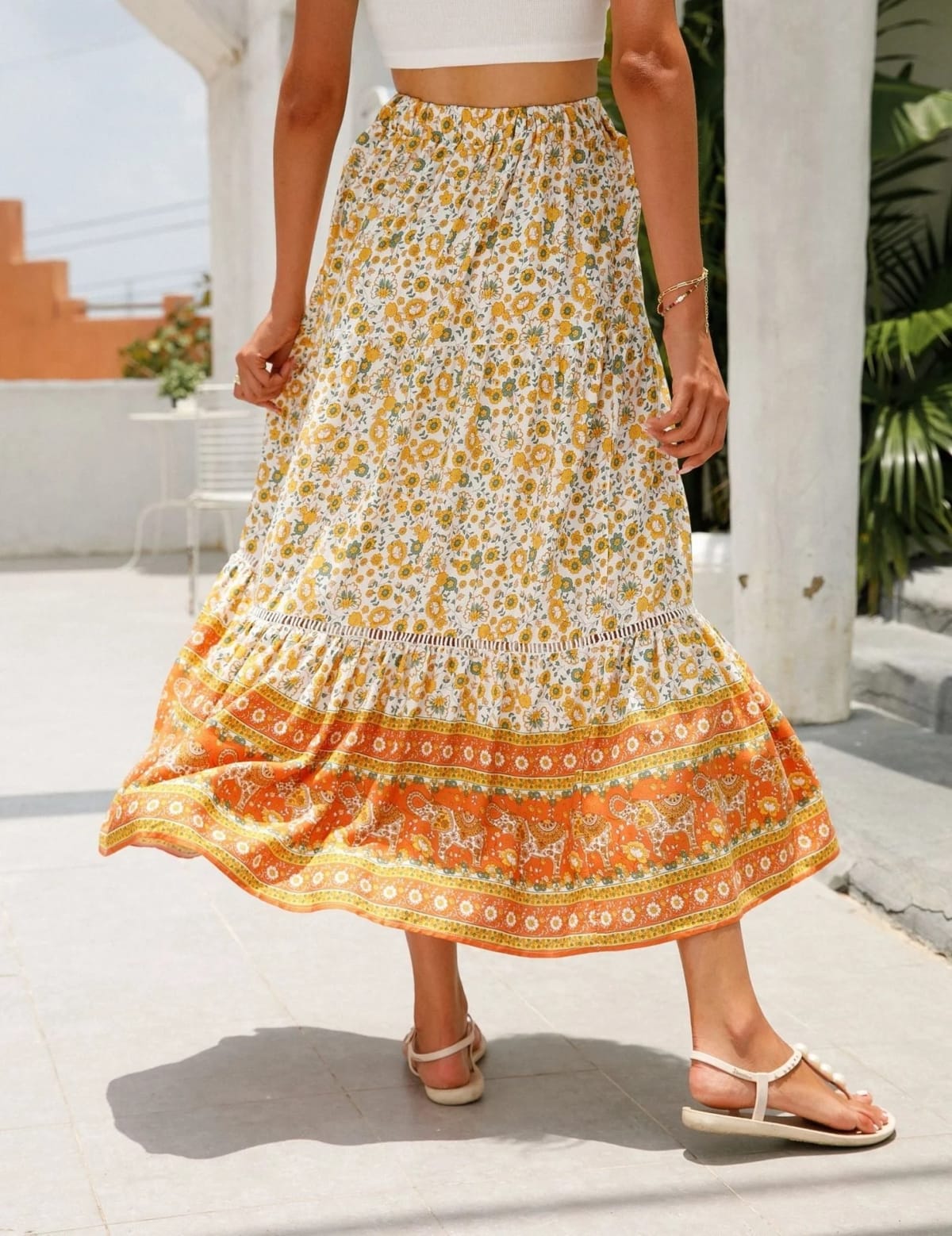 Woman wearing floral tiered midi skirt with crop top.