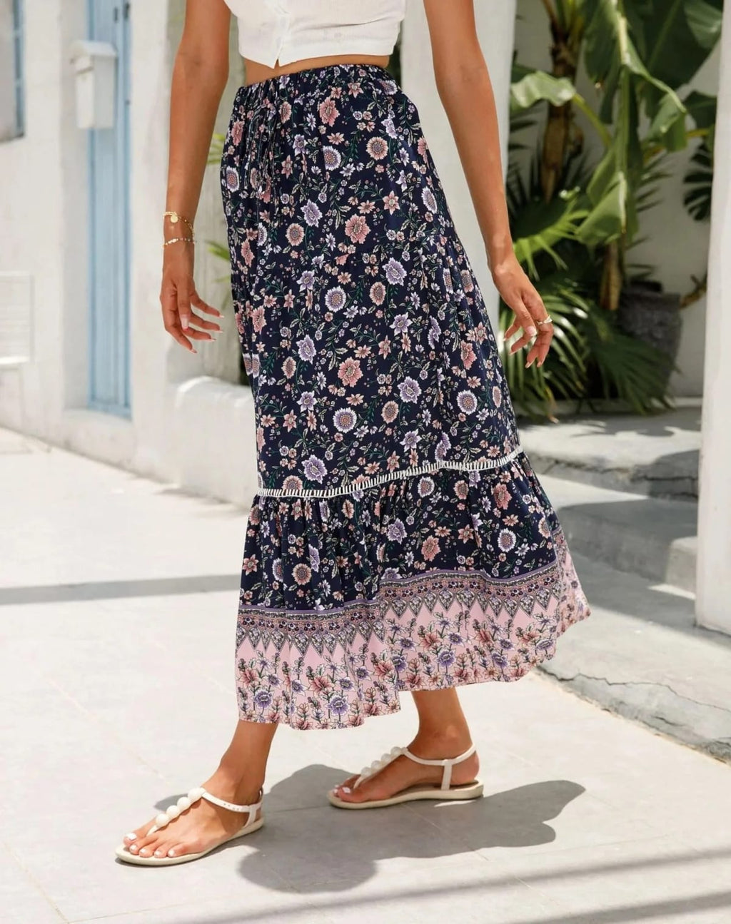 Woman wearing floral tiered midi skirt with crop top.