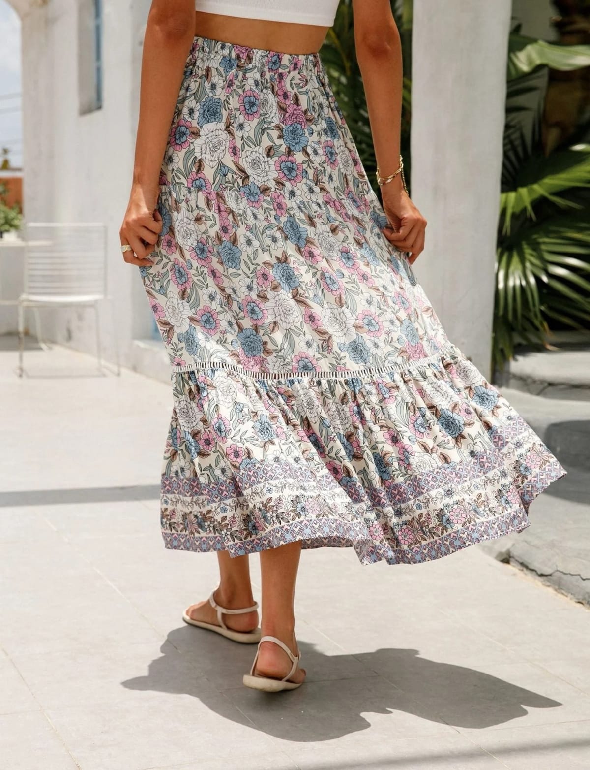 Woman wearing floral tiered midi skirt with crop top.