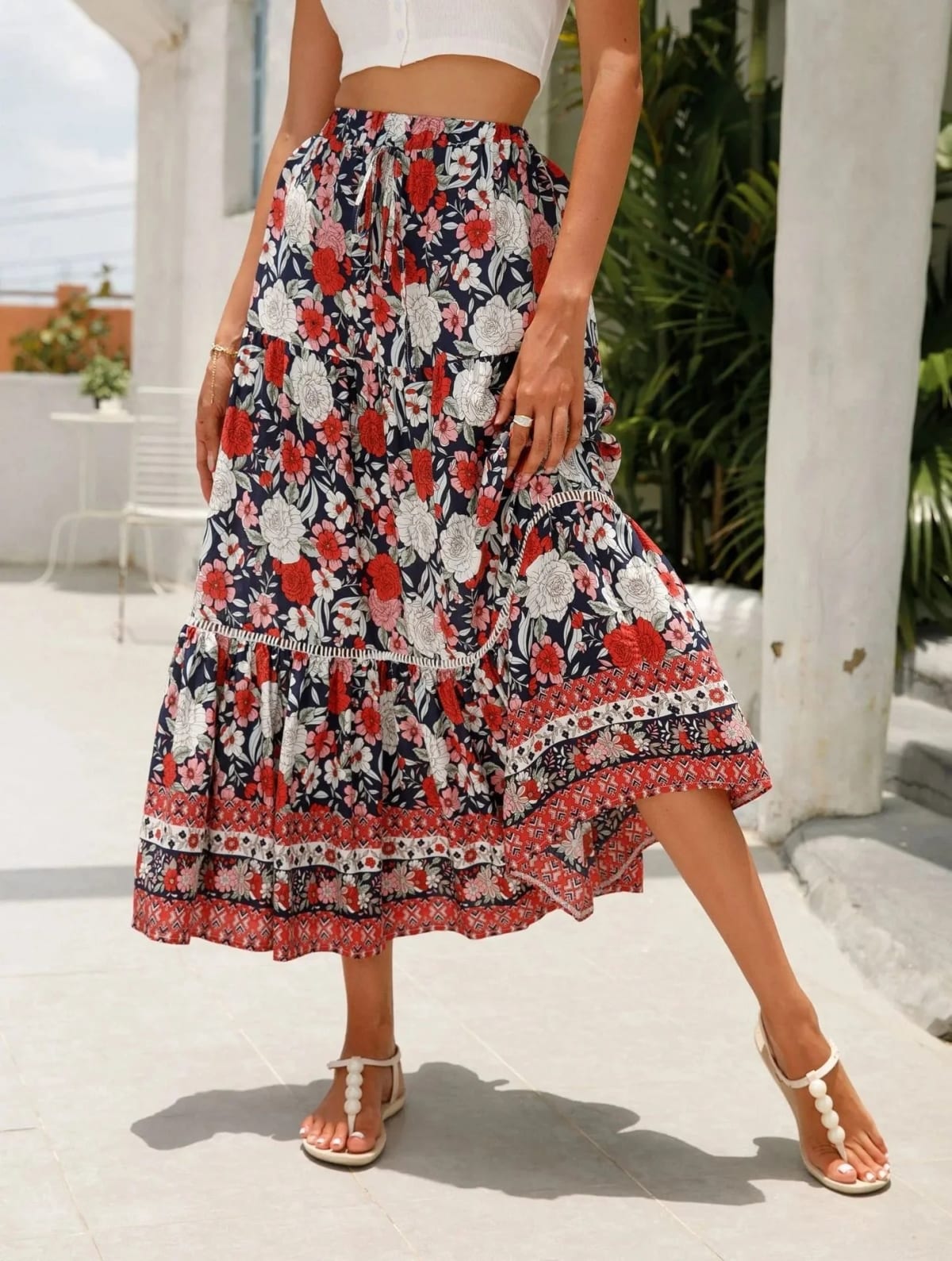 Woman wearing floral tiered midi skirt with crop top.