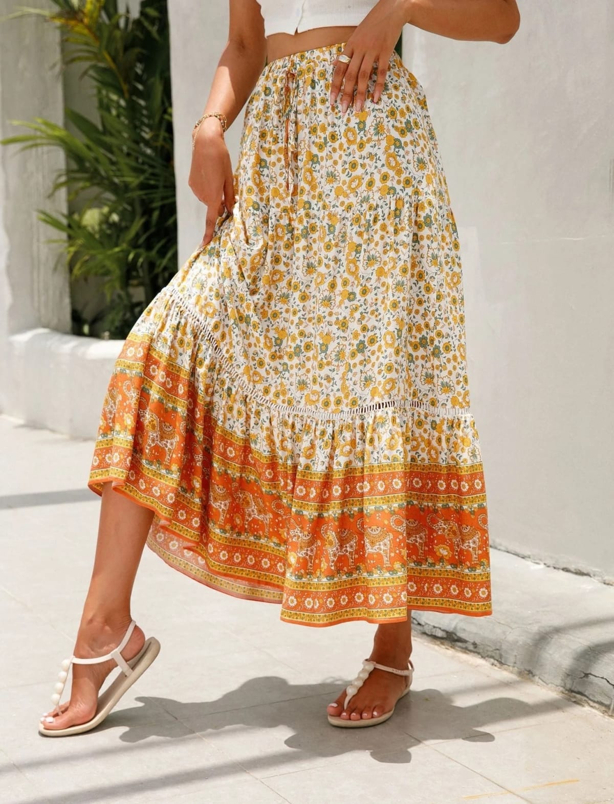 Woman wearing floral tiered midi skirt with crop top.