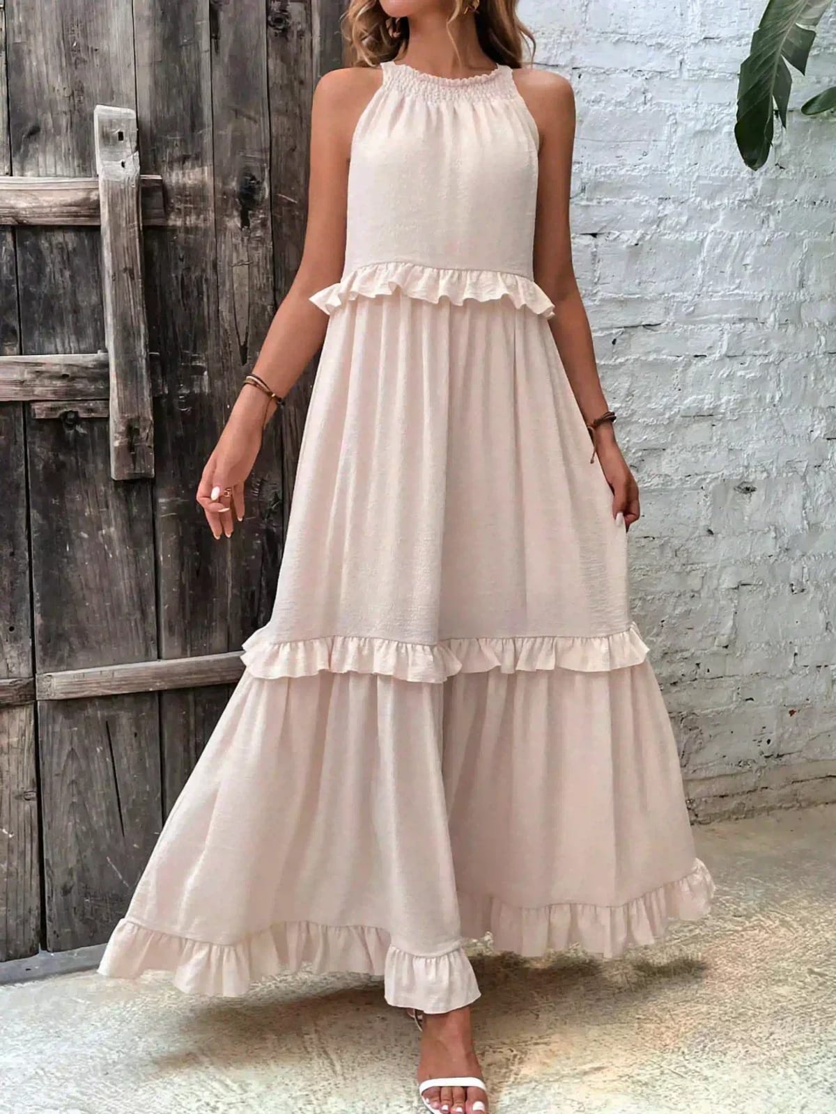 Sleeveless dress with ruffles, flowing fit, suitable for various occasions.