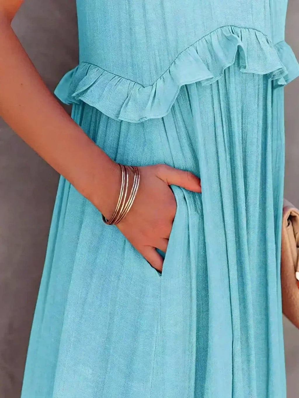 Sleeveless dress with ruffles, flowing fit, suitable for various occasions.