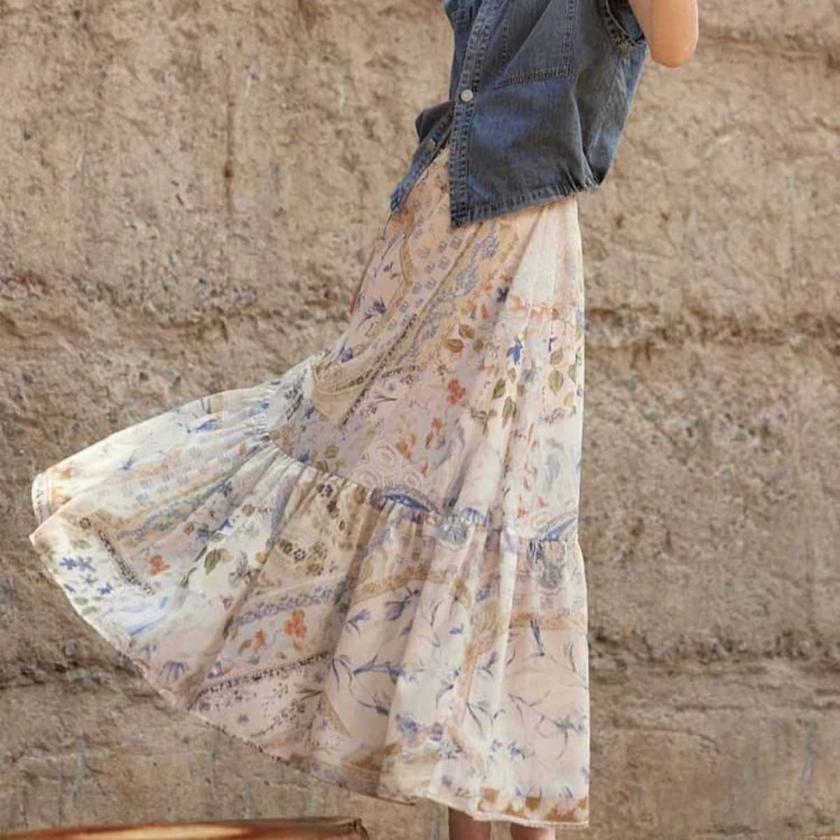 Cream-colored tiered maxi skirt with bohemian print and smocked waist.