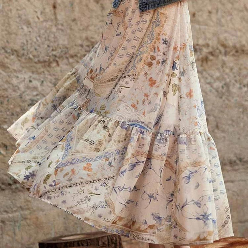 Cream-colored tiered maxi skirt with bohemian print and smocked waist.