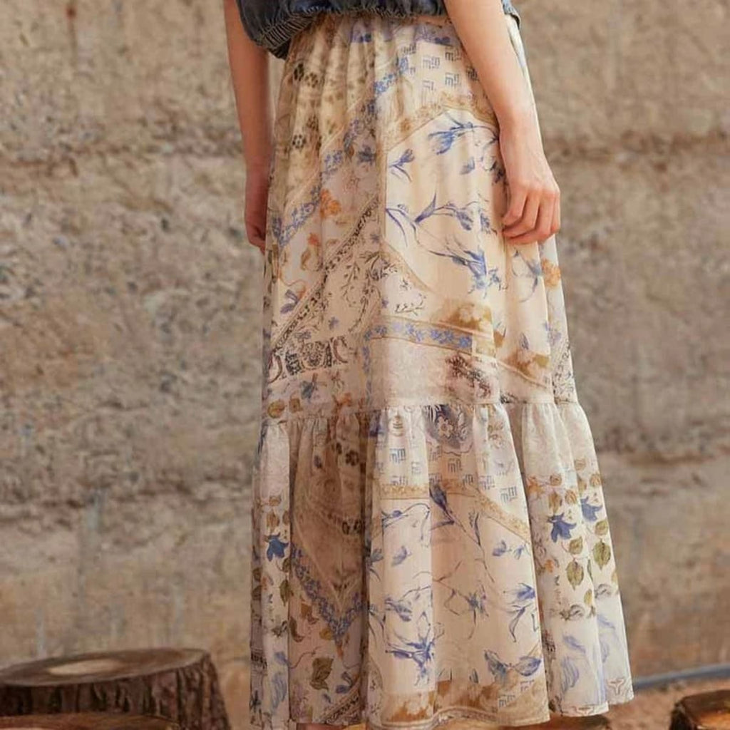 Cream-colored tiered maxi skirt with bohemian print and smocked waist.