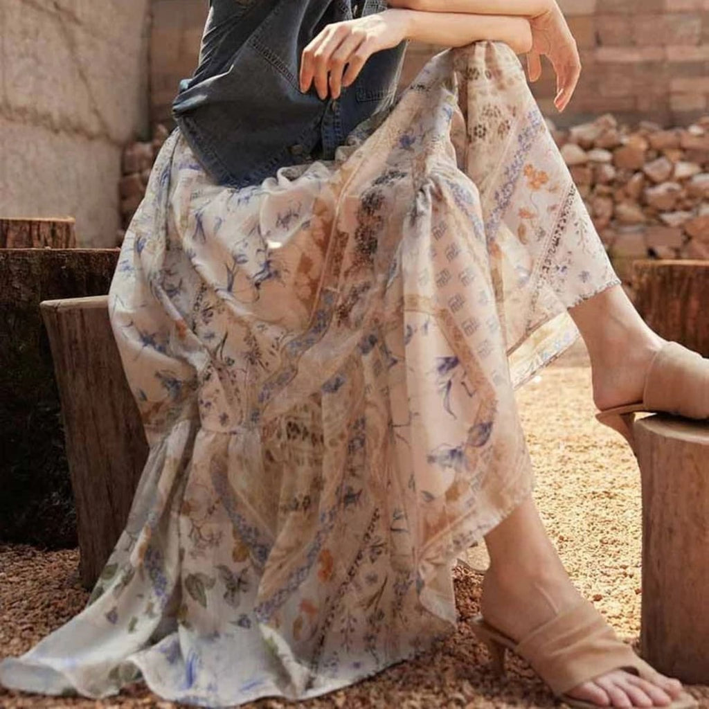 Cream-colored tiered maxi skirt with bohemian print and smocked waist.