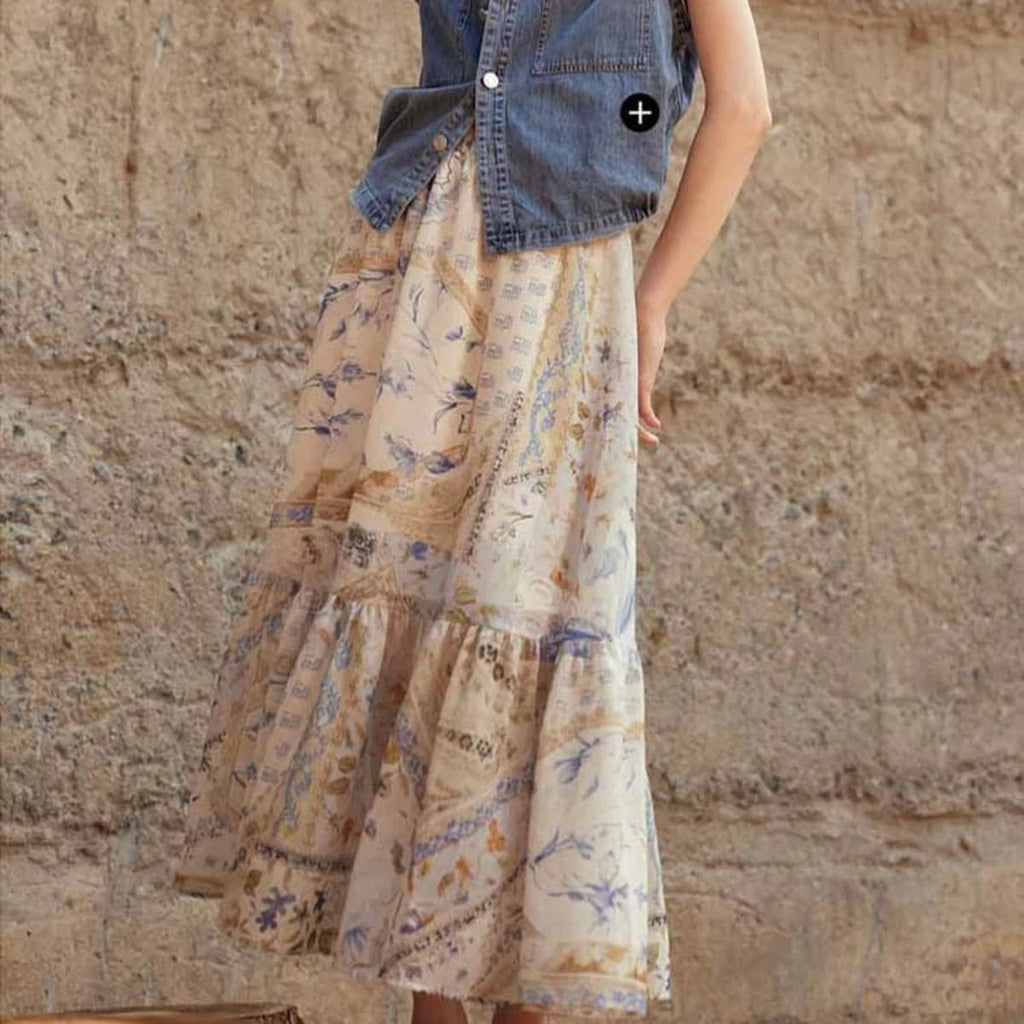 Cream-colored tiered maxi skirt with bohemian print and smocked waist.