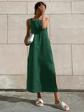 Woman in square neck midi dress with side slit against tiled wall.