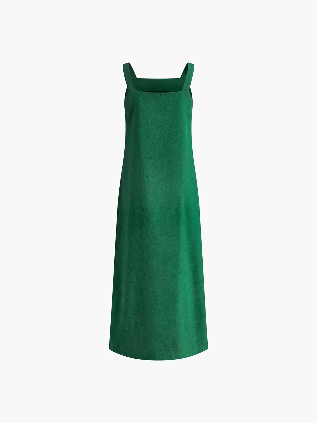 Woman in square neck midi dress with side slit against tiled wall.
