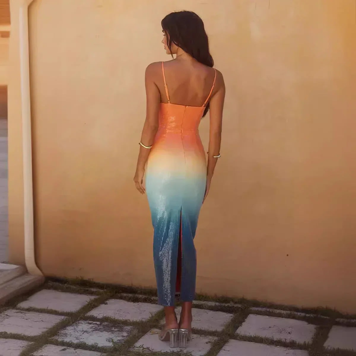Woman wearing a strappy ombre sequin maxi dress with a starfish detail.