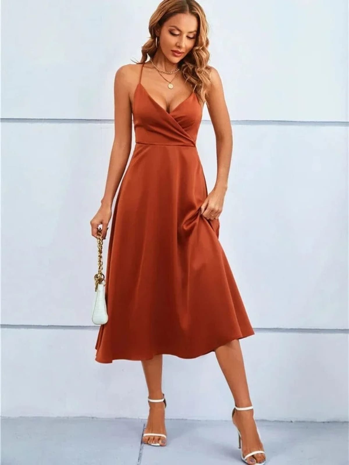 Woman in satin-finish wrap midi dress with spaghetti straps.