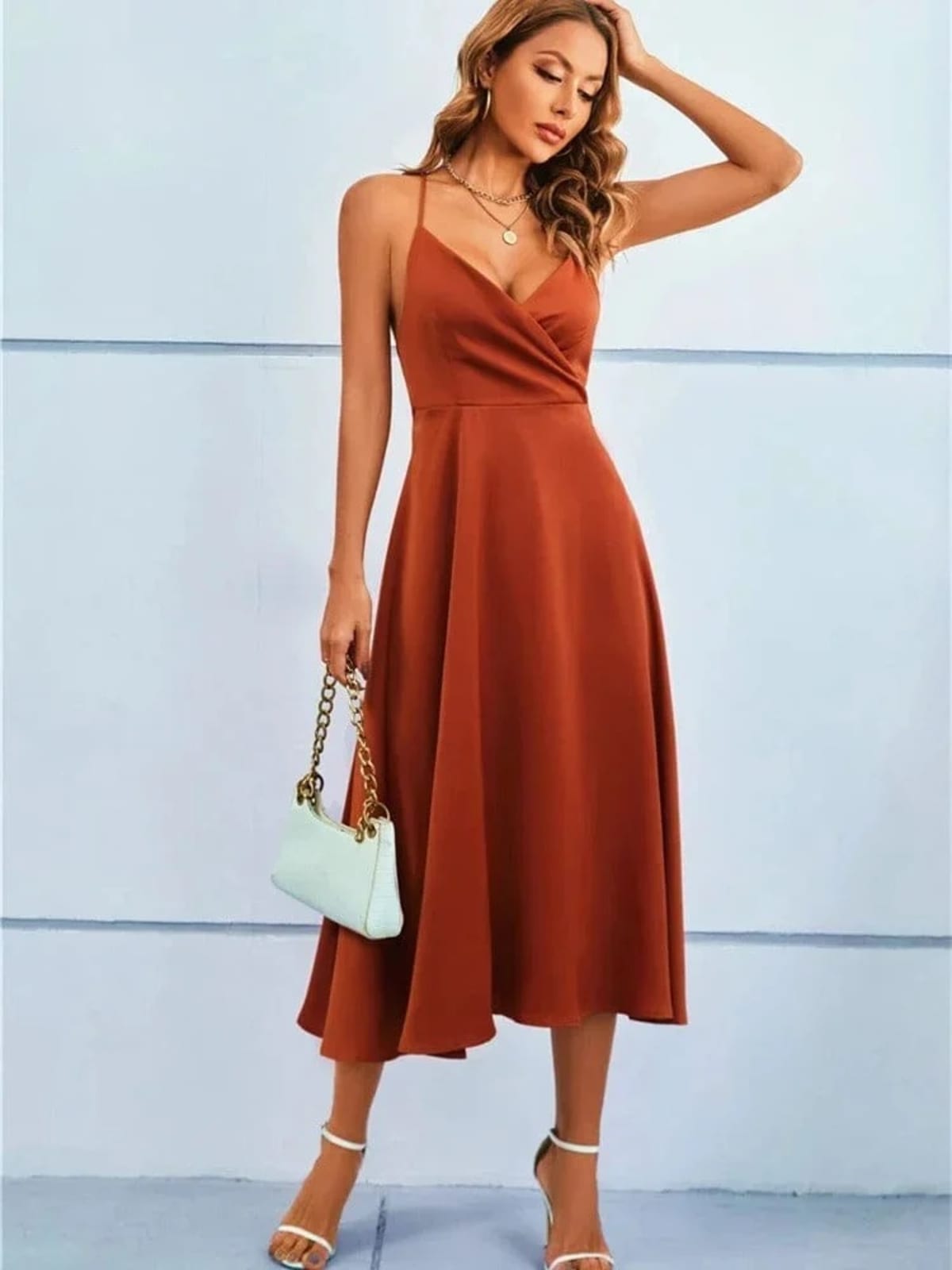 Woman in satin-finish wrap midi dress with spaghetti straps.