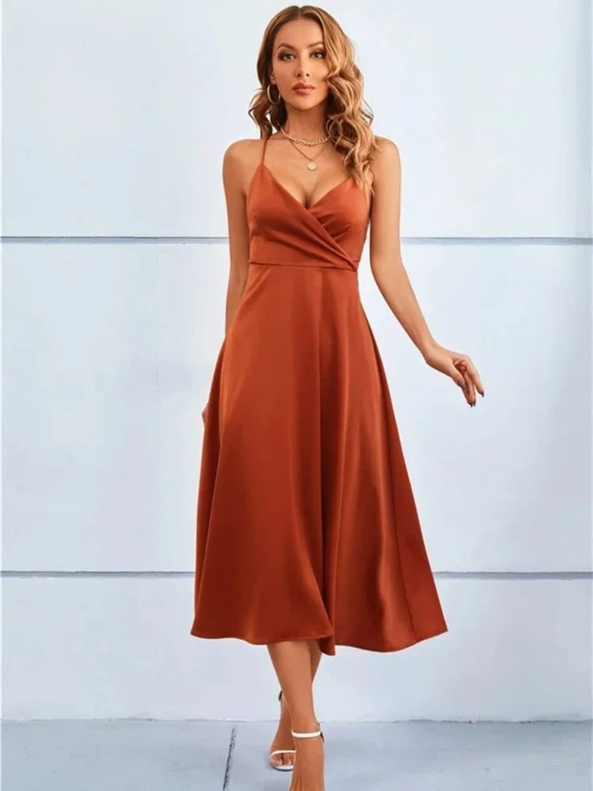 Woman in satin-finish wrap midi dress with spaghetti straps.