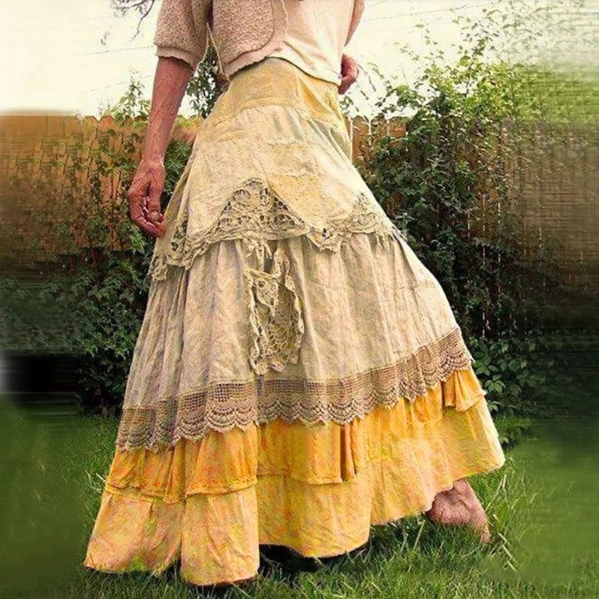 Person wearing a tiered maxi skirt with lace panels.