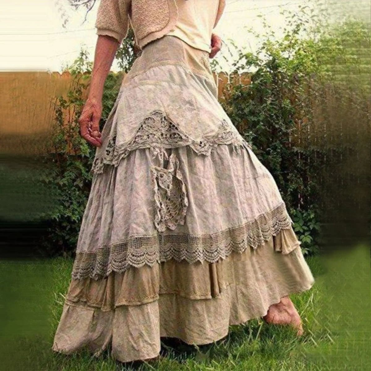 Person wearing a tiered maxi skirt with lace panels.