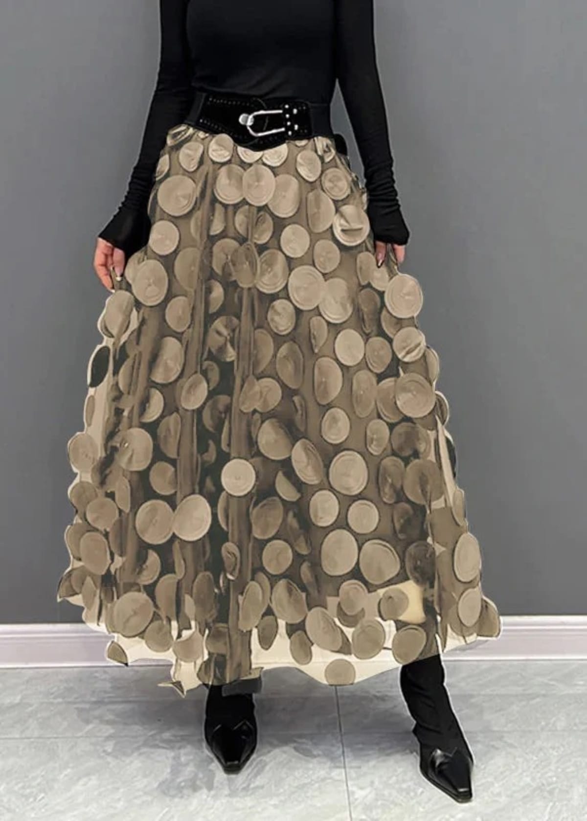 Person wearing a long maxi skirt with black round appliques on mesh.