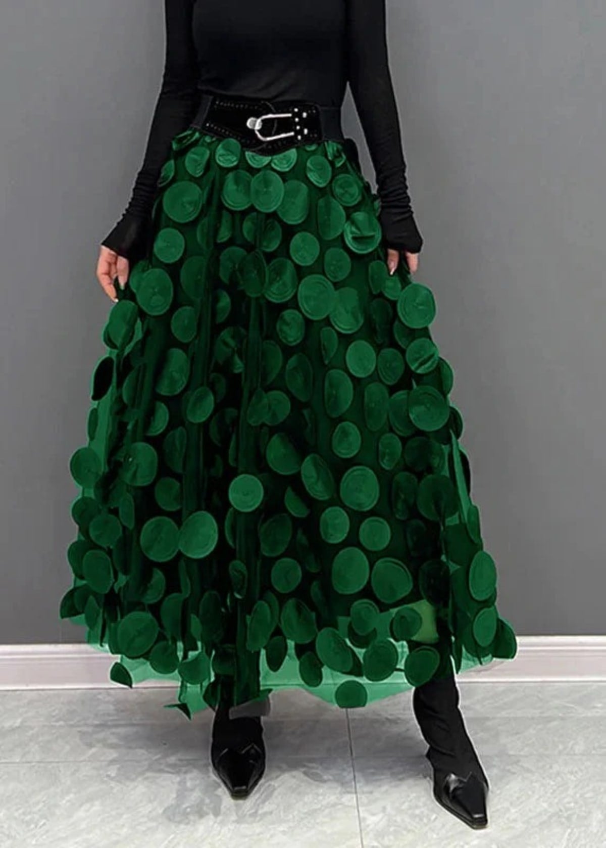 Person wearing a long maxi skirt with black round appliques on mesh.
