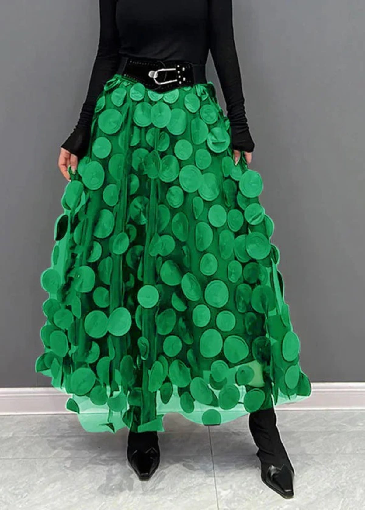 Person wearing a long maxi skirt with black round appliques on mesh.