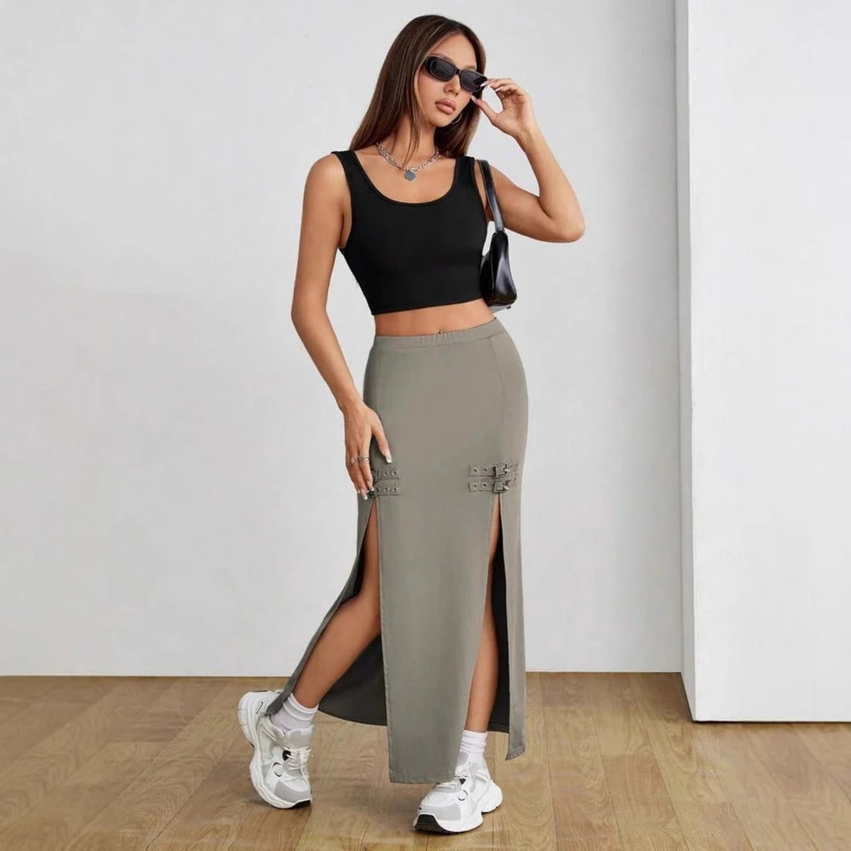 Woman wearing high-waisted maxi skirt with slits and buckle details.