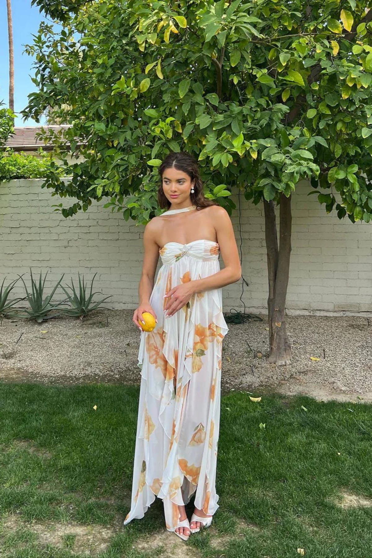Flowing halter neck maxi dress with empire waist and layered design.